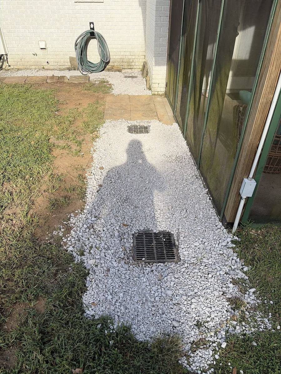 Finished catch basin set in a gravel bed along the side of a Northshore home