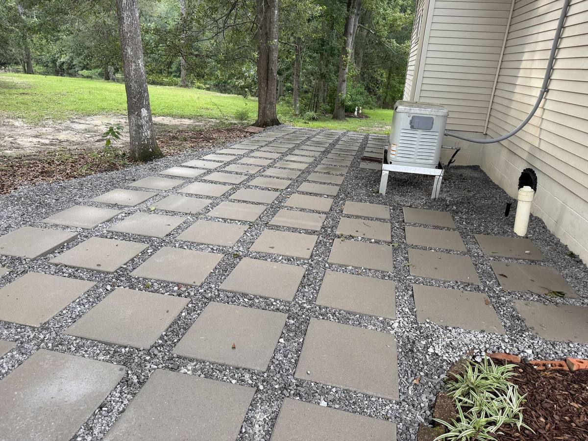 Wide paver path set in gravel connecting the side yard to the backyard